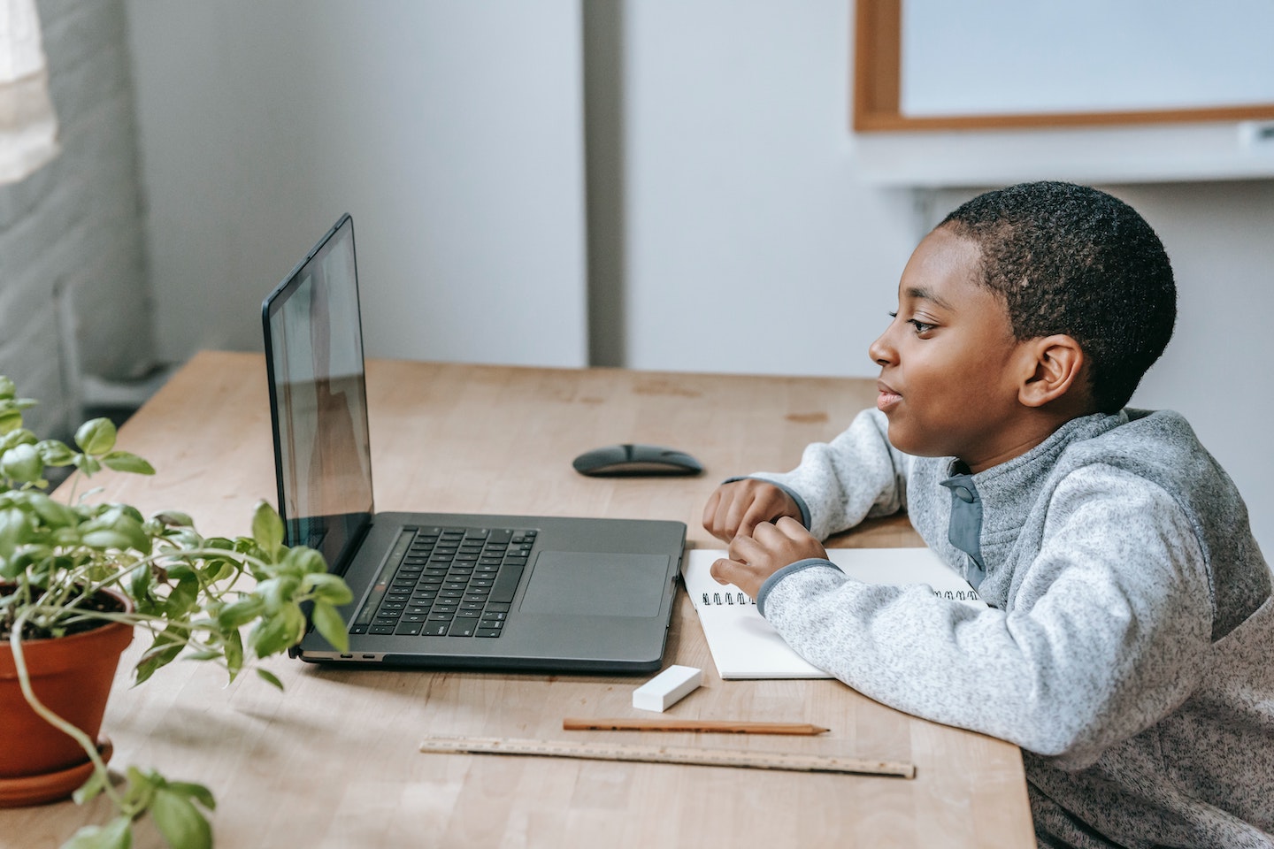 boy sitting in front of his laptop for online class (by PlatoForms Online Forms)