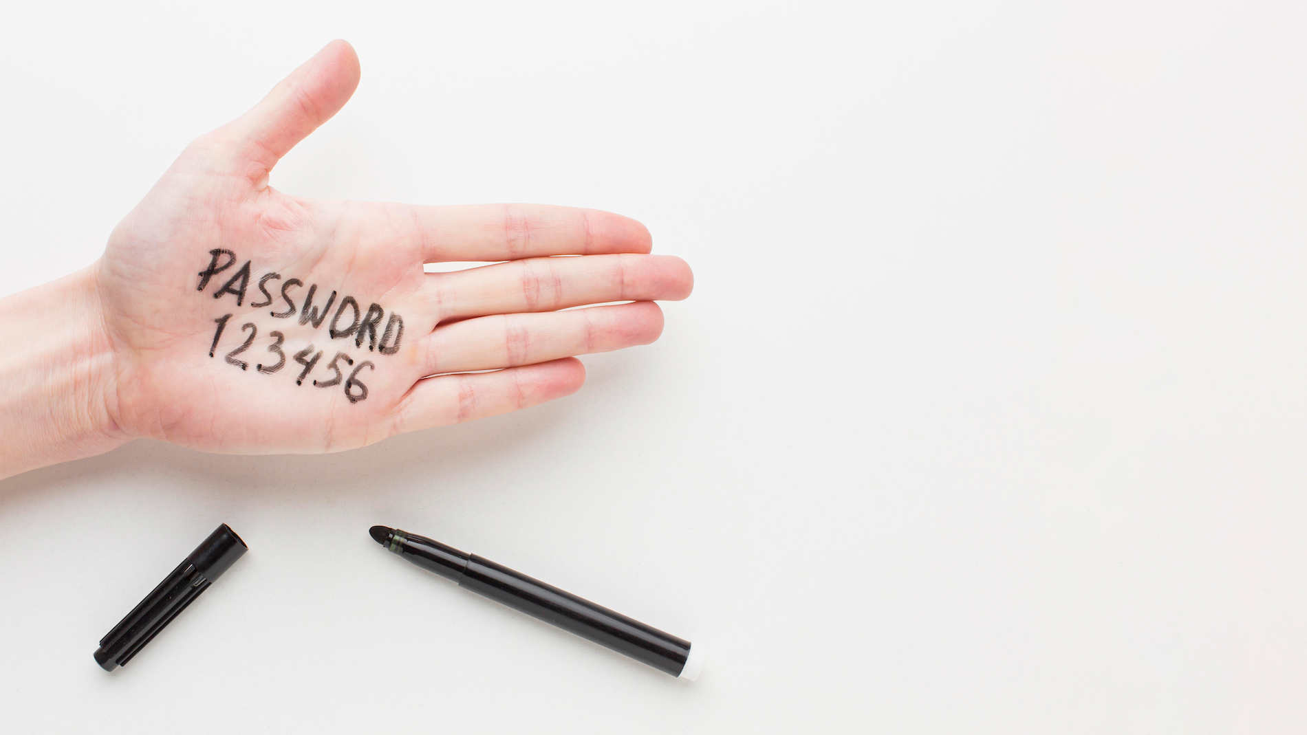 A person's hand writing down a password, representing the vulnerability of sharing decryption keys with online tools