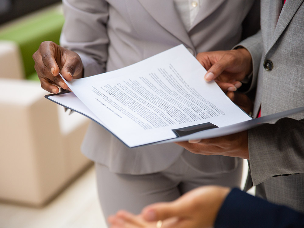 businessmen and woman holding a paper agreement form (by PlatoForms Online PDF Form Creator)